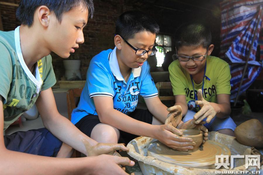 在柳城县沙埔镇一家陶瓷工艺厂,几名小学生动手学习陶瓷制作工艺(邓克