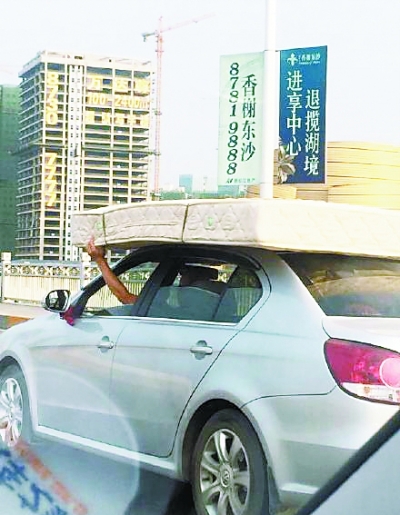 本报讯（记者李爱华）“一辆疾驰的轿车车顶上装了个床垫，而司机竟然伸出一只手将床垫扶着……”昨天，网友“糖糖”发布微博，讲述其亲眼所见的惊险一幕。