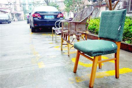 小区抢车位：老人坐板凳驻守 电动车锁铁链占地