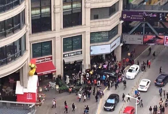 女司机误踩油门致车子失控 路人被夹在车头与墙体之间