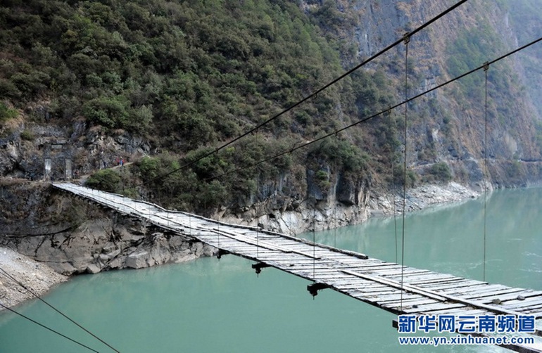 【怒江大峡谷】位于滇西横断山纵谷区三江并流地带，峡谷在云南段长达300多公里，平均深度为2000米，最深处在贡山丙中洛一带，达3500米被称为“东方大峡谷”。海拔4000多米的高黎贡山和碧罗雪山夹着水流汹涌的怒江，峡谷中险滩遍布，两岸山势险峻，层峦叠峰，比较有名的景观有双纳洼地嶂峡、利沙底石月亮、月亮山、马吉悬崖、丙中洛石门关、怒江第一湾、腊乌崖瀑布、子楞母女峰、江中松等。怒江大峡谷分布傈僳族、怒族、独龙族、白族、普米族等十几种少数民族，民俗风情独特、神秘！图为怒江峡谷吊桥（2011年12月23日摄）新华社记者 杨宗友 摄
