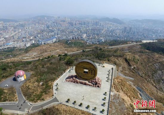 3月1日,湖南桂阳宝山国家矿山公园上的巨型铜钱雕塑吸引了众多游客