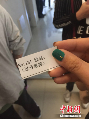 记者在上午办公时间结束后拿到的排号卡.中新网种卿摄