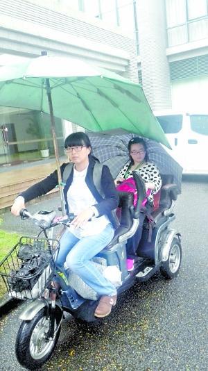  黄惠鹂骑车送女儿去上课。