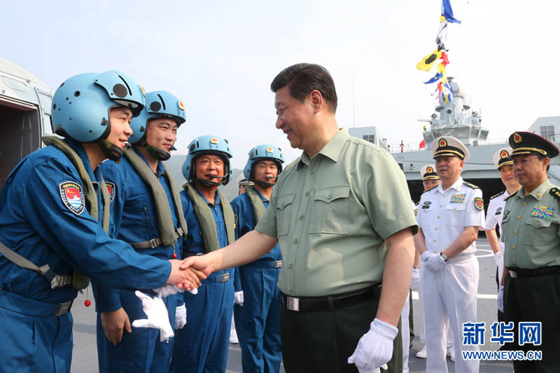 2013年4月9日，习近平在井冈山舰上与舰载直升机飞行员亲切握手。李刚摄