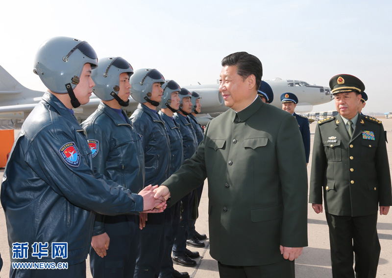 2015年2月16日，习近平同空军航空兵某团飞行机组和机务人员握手交谈。李刚摄
