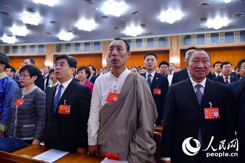 中国共产党第十九次全国代表大会开幕会现场，代表起立唱国歌。（人民网记者 翁奇羽 摄）