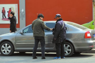 彰化路北侧，一名无证人员正在违规向车主收停车费。京华时报记者赵思衡摄