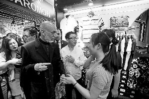 大图：卡尔扎伊在听店员介绍商品。