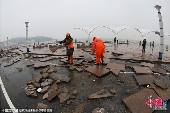 大量广场地砖被大浪冲到烟台市海岸路上。