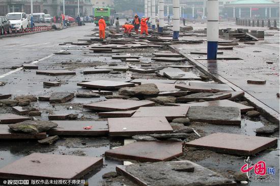 大量广场地砖被大浪冲到烟台市海岸路上。